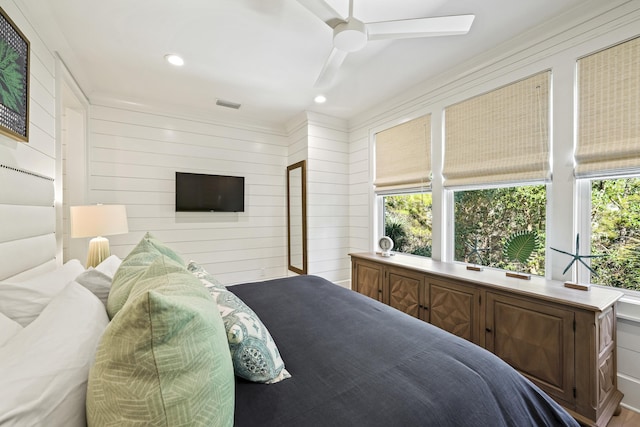 bedroom with wooden walls, visible vents, and recessed lighting