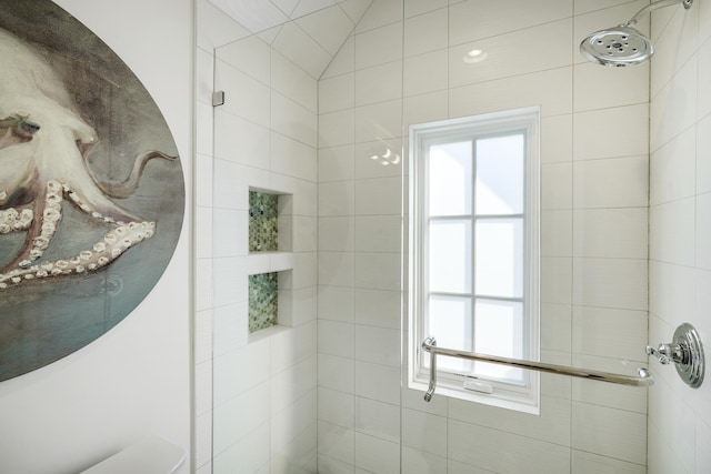 full bath featuring a wealth of natural light and a tile shower