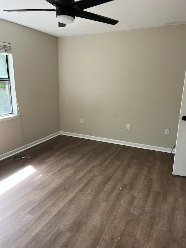 empty room with ceiling fan and dark wood-type flooring