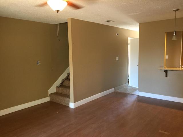 unfurnished room featuring ceiling fan, a textured ceiling, and hardwood / wood-style flooring