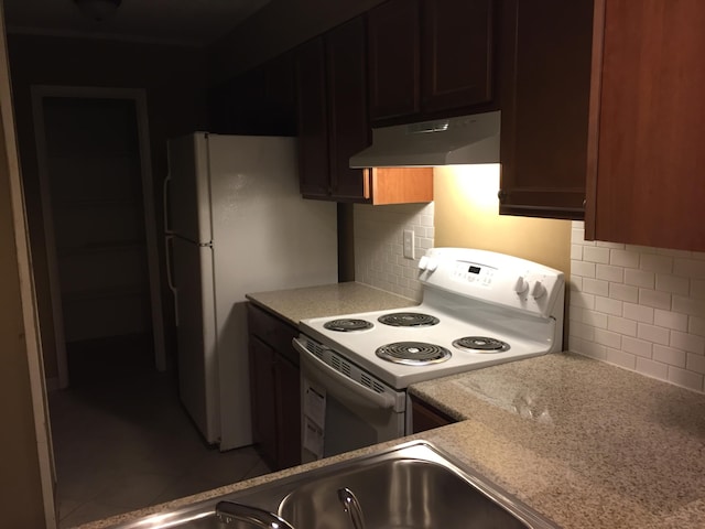 kitchen featuring backsplash and white appliances