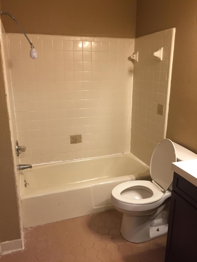 full bathroom featuring tile patterned floors, tiled shower / bath combo, toilet, and vanity