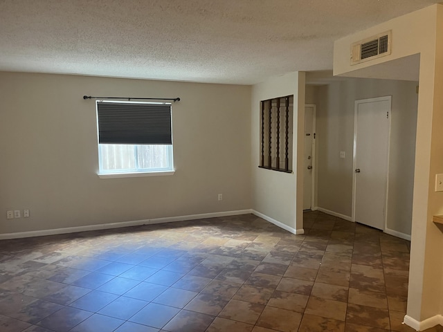 unfurnished room featuring a textured ceiling