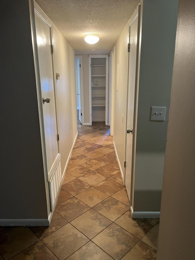 hall with a textured ceiling