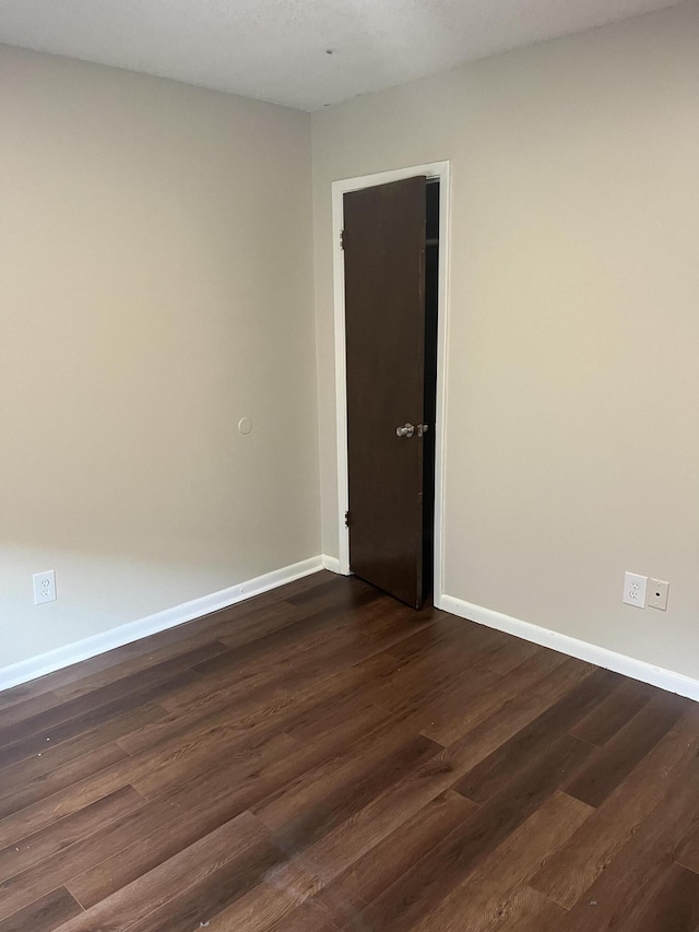 spare room with dark wood-type flooring