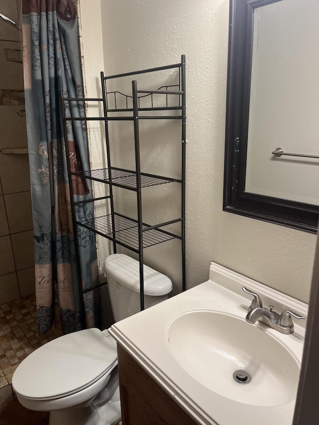 bathroom with vanity, toilet, and walk in shower