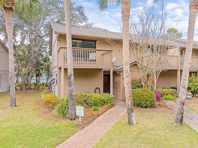 multi unit property featuring a balcony and a front yard