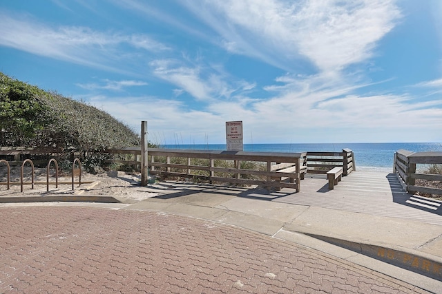 view of community with a water view and a beach view