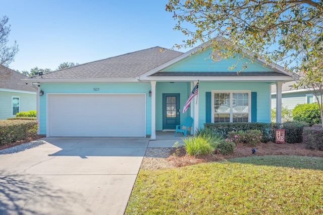 view of front of home with covered porch, a front yard, and a garage