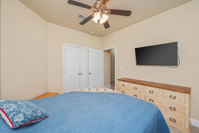 carpeted bedroom with ceiling fan and a closet