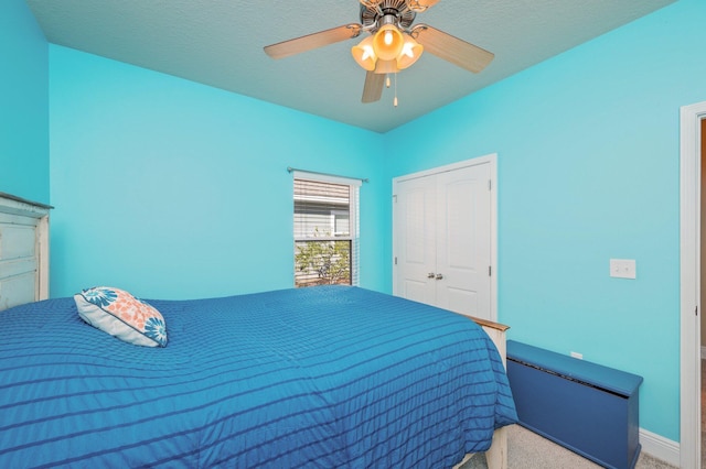 carpeted bedroom featuring ceiling fan and a closet