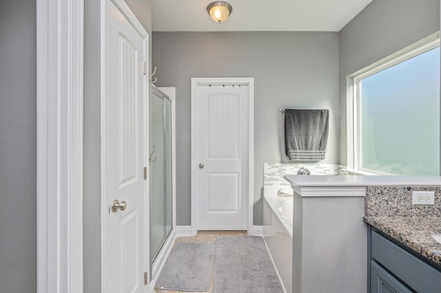 bathroom featuring tile patterned flooring, vanity, and shower with separate bathtub