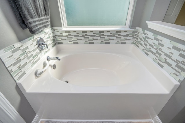 bathroom with a washtub and tasteful backsplash