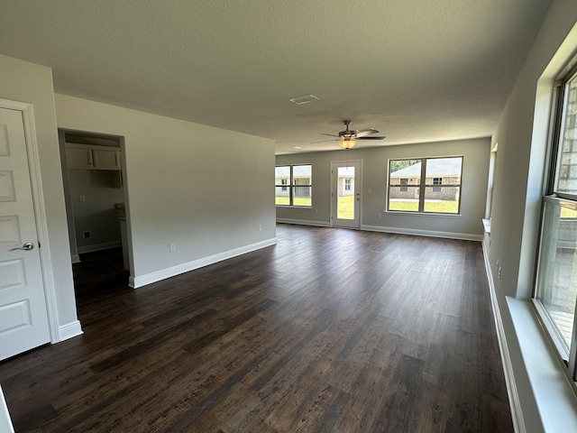 unfurnished living room featuring dark hardwood / wood-style floors, ceiling fan, and a textured ceiling