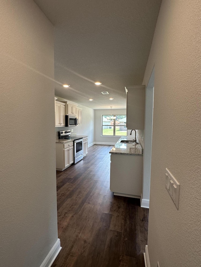 169 Ridgeway Cir, Crestview, FL 32536 - kitchen featuring appliances with stainless steel finishes, a chandelier, dark wood-style flooring, a textured wall, and recessed lighting