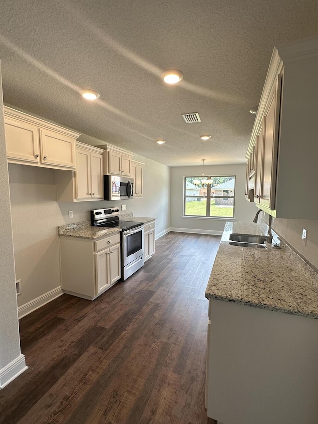 169 Ridgeway Cir, Crestview, FL 32536 - kitchen featuring appliances with stainless steel finishes, a chandelier, dark wood-style flooring, a textured ceiling, and light stone counters