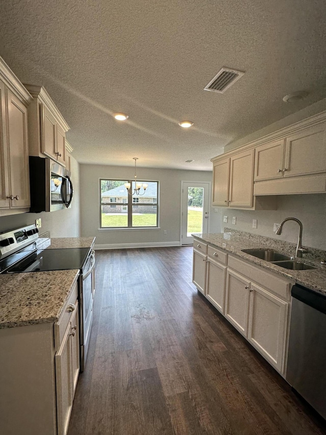 169 Ridgeway Cir, Crestview, FL 32536 - kitchen with appliances with stainless steel finishes, dark wood-type flooring, a chandelier, healthy amount of natural light, and a textured ceiling