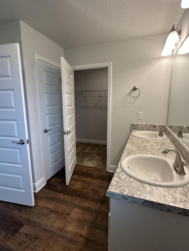 bathroom featuring hardwood / wood-style floors, vanity, and a textured ceiling