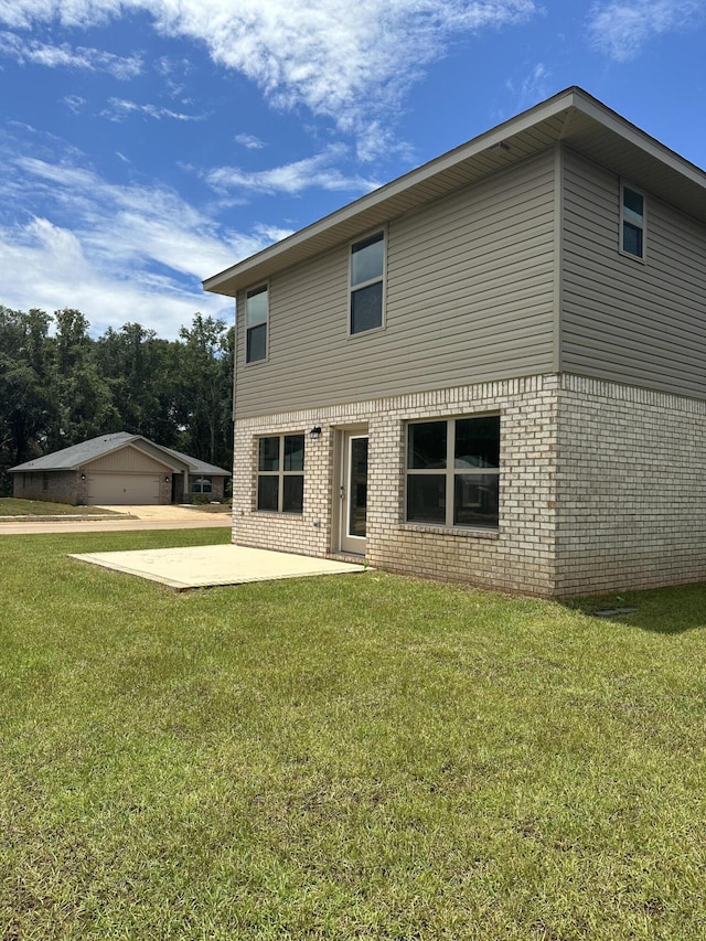 rear view of house with a yard, a patio, and a garage