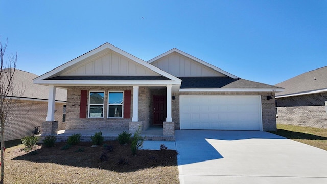 view of front facade featuring brick siding, a porch, an attached garage, board and batten siding, and driveway