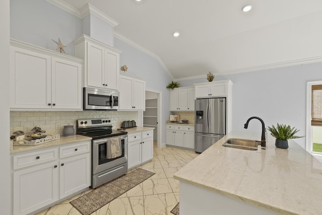 kitchen featuring lofted ceiling, white cabinetry, sink, and appliances with stainless steel finishes