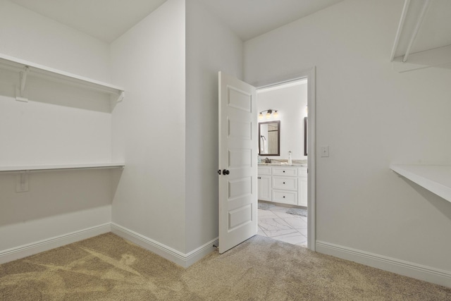 walk in closet featuring light carpet