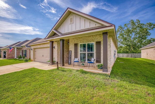 view of front of home featuring a porch, a garage, and a front lawn