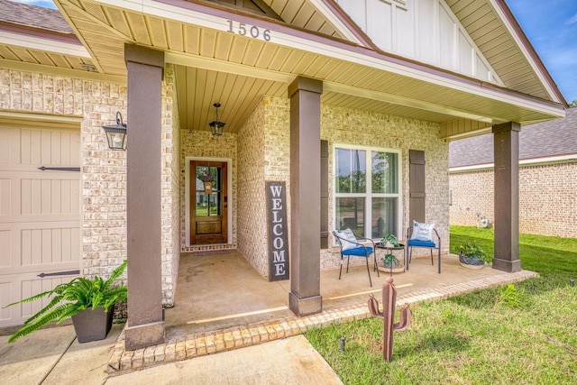 view of exterior entry with a lawn, a garage, and covered porch