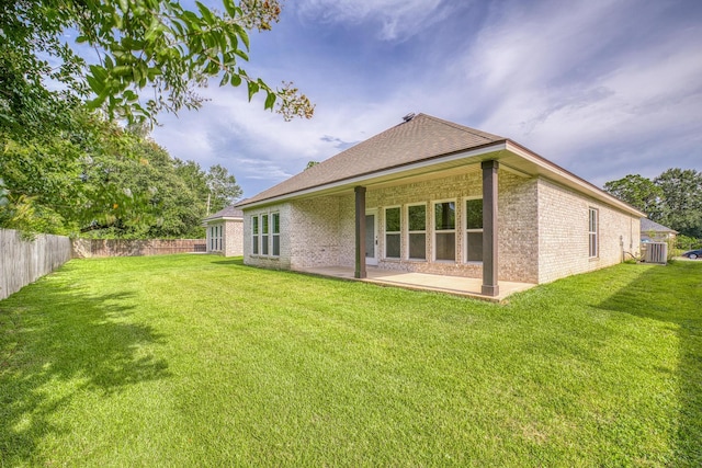 rear view of property featuring central air condition unit, a patio area, and a yard