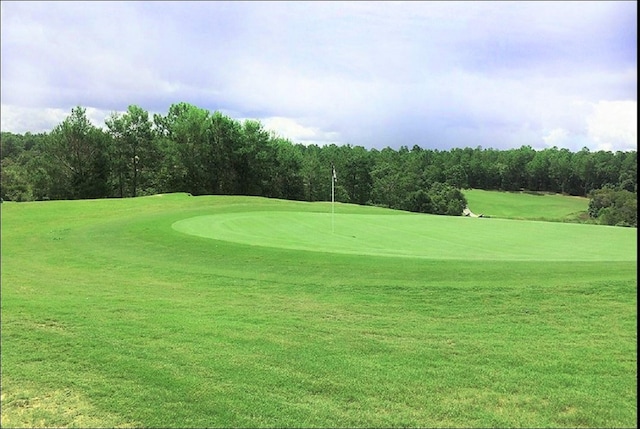 view of home's community with view of golf course and a lawn