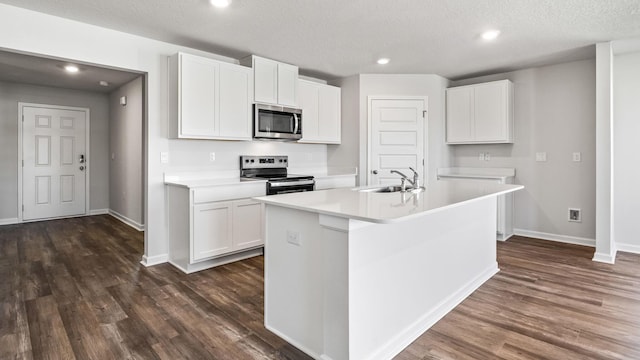 kitchen featuring appliances with stainless steel finishes, sink, a center island with sink, and white cabinets