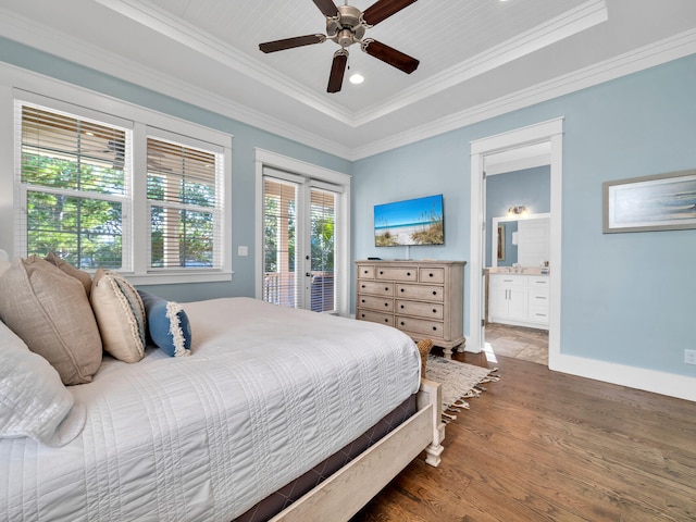 bedroom with dark hardwood / wood-style flooring, ensuite bathroom, a tray ceiling, ceiling fan, and crown molding