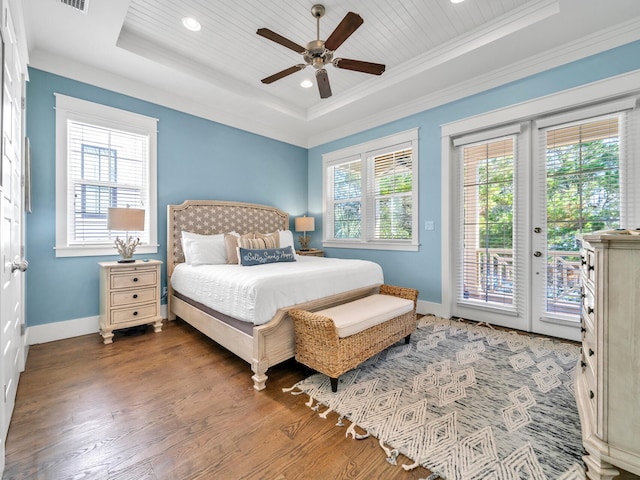 bedroom with hardwood / wood-style floors, a raised ceiling, ceiling fan, access to exterior, and ornamental molding