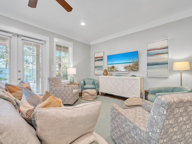 living room featuring carpet flooring, ceiling fan, and crown molding