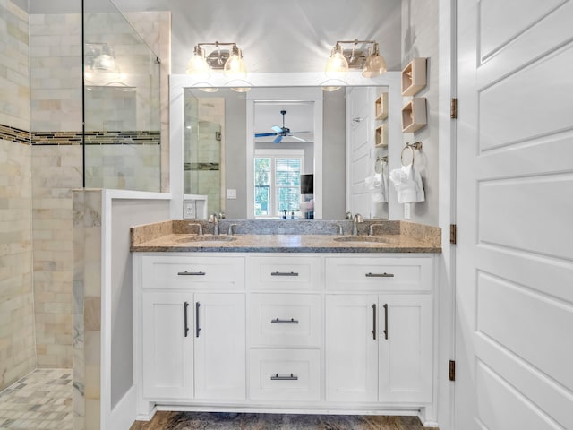 bathroom with ceiling fan, vanity, and tiled shower