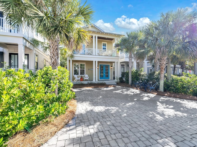 view of front of property featuring covered porch, french doors, and a balcony