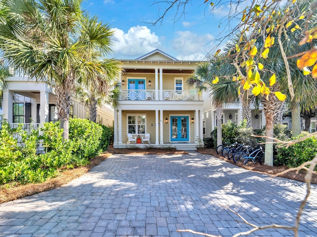 view of front of property featuring french doors, a balcony, and a porch