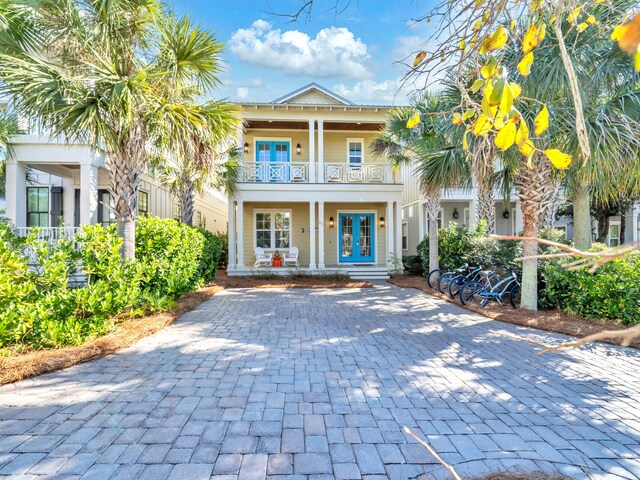 view of front of property with covered porch, french doors, and a balcony