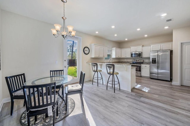 dining area with a notable chandelier and light wood-type flooring