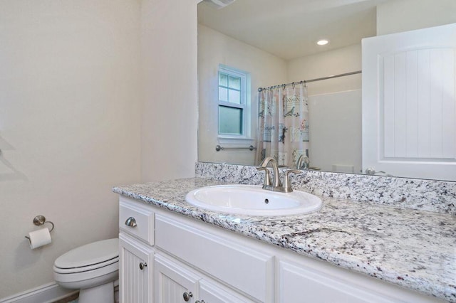 bathroom with vanity, curtained shower, and toilet