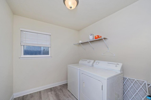 laundry area with washer and dryer and light hardwood / wood-style floors