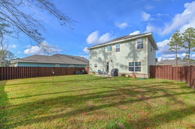 rear view of house featuring a patio area and a yard