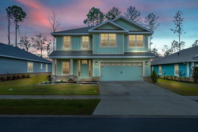 craftsman inspired home featuring a garage and a yard