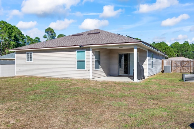 rear view of property with central air condition unit, a patio area, and a lawn