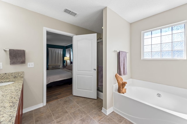 bathroom featuring vanity, a textured ceiling, and independent shower and bath