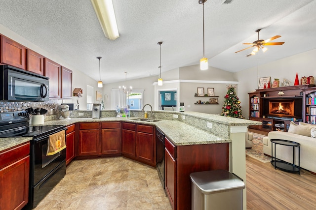 kitchen with pendant lighting, lofted ceiling, black appliances, sink, and kitchen peninsula