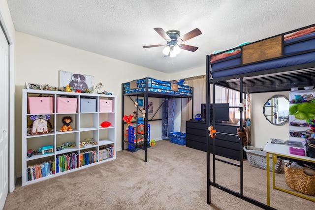 carpeted bedroom featuring ceiling fan and a textured ceiling