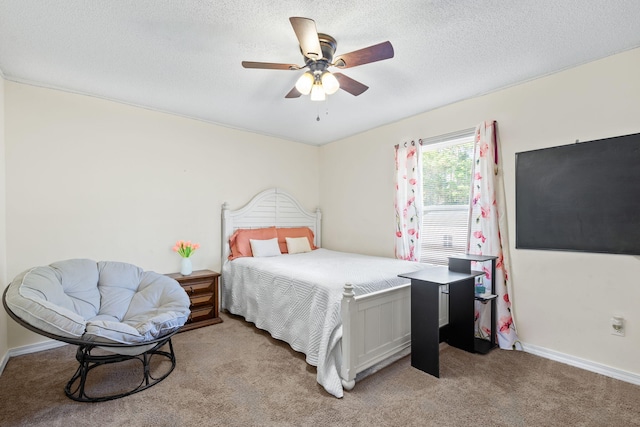 bedroom with ceiling fan, light carpet, and a textured ceiling