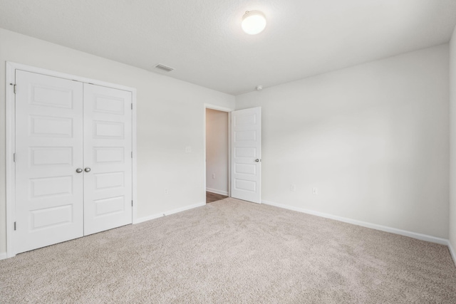 unfurnished bedroom with carpet floors and a closet