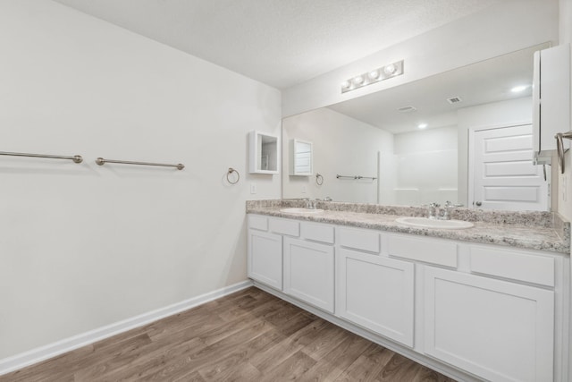 bathroom featuring hardwood / wood-style floors, vanity, and a textured ceiling